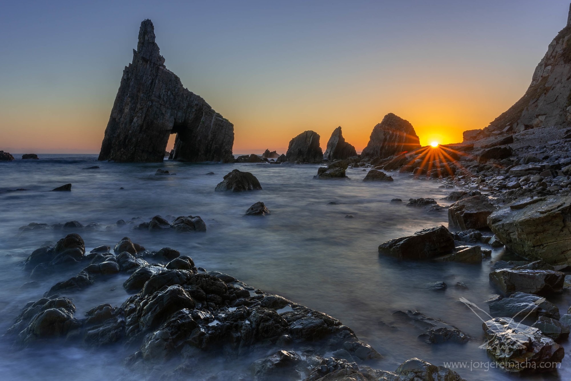 Costa de Cadavedo al amanecer con peña horadada